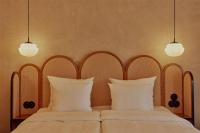 a bedroom with two beds with white pillows and two lights at NH Copenhagen Grand Joanne in Copenhagen