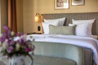 a bedroom with a bed and a couch and flowers at NH Copenhagen Grand Joanne in Copenhagen