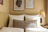 a bedroom with a bed with white sheets and pillows at NH Copenhagen Grand Joanne in Copenhagen