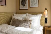 a bed with white sheets and a pillow on it at NH Copenhagen Grand Joanne in Copenhagen