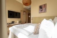 a bedroom with a white bed and a television at NH Copenhagen Grand Joanne in Copenhagen