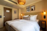 a large white bed in a hotel room at NH Copenhagen Grand Joanne in Copenhagen
