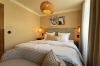 a hotel room with two beds and a chair at NH Copenhagen Grand Joanne in Copenhagen