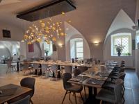 Un comedor con mesas y sillas y una lámpara de araña. en Zámek Světlá nad Sázavou, en Světlá nad Sázavou
