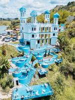 an aerial view of a resort with blue tables at Hotel y Termales Castillo Del Lago Guatape in Horizonte
