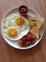 ein Teller mit Eiern und Toast und einem Esslöffel Ketchup in der Unterkunft The Joy Rooms Penida in Toyapakeh