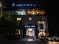 塔什干Avant Wellness Hotel Pool&Spa, Free airport shuttle service的夜幕降临，一家阿曼特酒店外停满了汽车。
