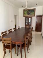 Un comedor con mesa y sillas de madera. en Stationmaster's Lodge Polhena, en Matara