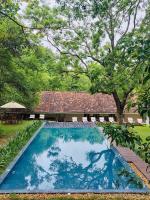 a swimming pool in front of a house with trees at EKHO Sigiriya - 700 meters to Sigiriya Rock in Sigiriya