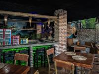 ツァニーンにあるThe Red Oak Guesthouseのレストラン内の木製のテーブルと椅子のあるバー