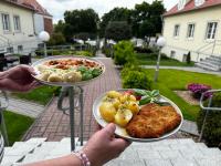 een persoon met twee borden met voedsel erop. bij Adalbertus Dom Pielgrzyma in Gniezno