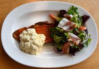 Un plato blanco con un sándwich y una ensalada. en LOGIS Hotel Restaurant Le KALLISTE, en Hyères