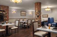 un restaurant avec des tables et des chaises et une cheminée dans l'établissement National Hotel Jackson, Tapestry Collection by Hilton, à Jackson