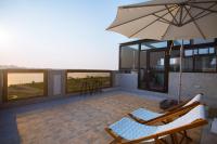 a patio with two chairs and an umbrella at Malibu OceanView Homestay in Magong