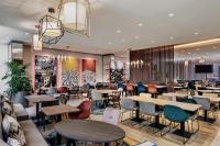 a restaurant with tables and chairs and a lobby at Hampton By Hilton Venice Isola Nuova in Venice