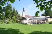a building with a tower on top of a grass field at Gartenhotel Kloepferkeller in Eibiswald
