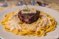 a plate of food with a piece of meat and pasta at Visconte Ditalia Hotel e Eventos - Próximo a Gramado in Nova Hartz