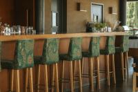 Herdade da Cortesia Hotel في أفيس: بار به مقاعد خضراء في مطعم