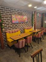 een restaurant met tafels en stoelen en een bakstenen muur bij Waalay Hotel in Huancayo