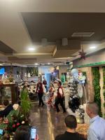 um grupo de pessoas andando por uma loja com decorações de Natal em Хотел Дива em Blagoevgrad