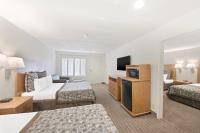 a hotel room with two beds and a television at Anaheim Desert Inn & Suites in Anaheim