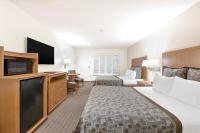 a hotel room with a bed and a flat screen tv at Anaheim Desert Inn & Suites in Anaheim
