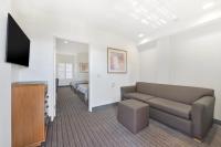 a living room with a couch and a tv and a bed at Anaheim Desert Inn & Suites in Anaheim