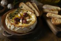 een taart op een houten bord met brood en noten bij Chateau de la Coutere in Saint-Laurent