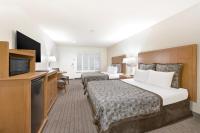 a hotel room with two beds and a flat screen tv at Anaheim Desert Inn & Suites in Anaheim