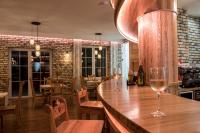 a bar with two glasses of wine on a table at Domki Perła Dunajca - Hotel Perła Dunajca in Czarny Dunajec
