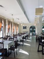 een eetkamer met tafels en stoelen en ramen bij Zajazd Emida 