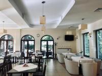 een eetkamer met tafels en stoelen en ramen bij Zajazd Emida 