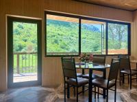 Un comedor con mesa y sillas y ventanas. en QarUp House, en Dilijan