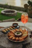 Una mesa con un plato de comida y una copa de vino. en Casa de Pedra Hotel Icaraizinho, en Icaraí