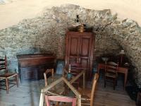a room with a table and chairs and a piano at A Chjusella di E Sertine in Tralonca