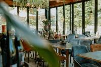 a restaurant with tables and chairs and windows at Hotel Jachtlust in Borne