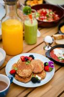 WellClub - Family Wellness & Sea View Suites في بافوس: طاولة بها فطائر وفواكه على طبق