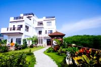 a large white building with a garden in front of it at Ibali Hostel in Magong