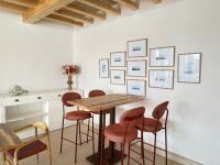 una sala da pranzo con tavolo e sgabelli in legno di Punta Candor Suites a Rota