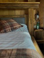 a bedroom with a bed with a wooden headboard at Hotel Roklina in Hrabušice