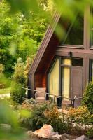 una casa con un porche cubierto con 2 sillas en Chalet by Provence Suceava, en Suceava