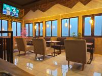 a dining room with chairs and tables and windows at Rayana Resort in Songgoriti