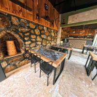 a restaurant with tables and chairs and a stone wall at Tikir House in Pamukkale