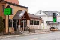 a building with a green sign in front of it at Auberge Le Chardo Inn 