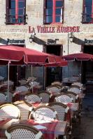 an outdoor restaurant with tables and chairs and umbrellas at La Vieille Auberge in Le Mont Saint Michel