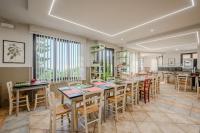 uma sala de jantar com uma mesa longa e cadeiras em Hotel della Brughiera em Trivero