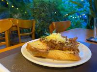 贡布Derm Svay Guesthouse - yoga & cafe的桌子上放着一个白色盘子，上面放着三明治和玉米。