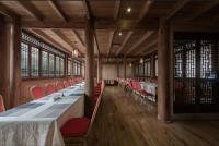 a dining room with long tables and red chairs at Shanyeji Garden Resort Panorama Hotel in Xinping