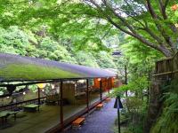 Un edificio con bancos y mesas en un bosque. en Takao Kanko Hotel, en Kioto