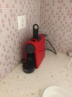 a red machine in the corner of a bathroom at Theofanis Studios in Agia Anna Naxos